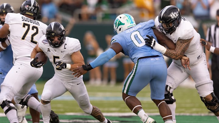 Dec 3, 2022; New Orleans, Louisiana, USA; UCF Knights running back Isaiah Bowser (5) rushes against Tulane Green Wave defensive lineman Patrick Jenkins (0) during the first half at Yulman Stadium.