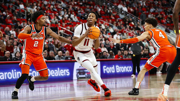 Jan 27, 2026; Raleigh, North Carolina, USA; NC State Wolfpack guard Quadir Copeland (11) dribbles with the ball  guarded by Syracuse Orange guard Nate Kingz (4) and guard JJ Starling (2) during the first half of the game at Lenovo Center. Mandatory Credit: Jaylynn Nash-Imagn Images