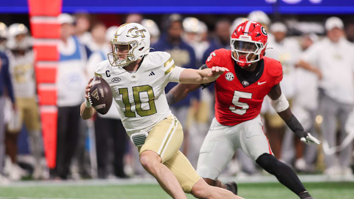 Nov 28, 2025; Atlanta, Georgia, USA; Georgia Tech Yellow Jackets quarterback Haynes King (10) scrambles past Georgia Bulldogs linebacker Raylen Wilson (5) in the first quarter at Mercedes-Benz Stadium. Mandatory Credit: Brett Davis-Imagn Images