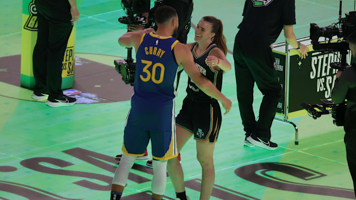 Feb 17, 2024; Indianapolis, IN, USA; New York Liberty guard Sabrina Ionescu (20) competes in the Stephen vs. Sabrina 3-Point Challenge against Golden State Warriors guard Stephen Curry (30) during NBA All Star Saturday Night at Lucas Oil Stadium. Mandatory Credit: Trevor Ruszkowski-Imagn Images