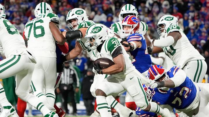 Jan 4, 2026; Orchard Park, New York, USA; New York Jets running back Khalil Herbert (31) avoids a tackle by Buffalo Bills defensive tackle Phidarian Mathis (72) during the third quarter at Highmark Stadium. 