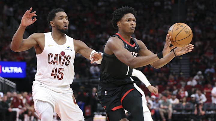 Dec 27, 2025; Houston, Texas, USA;  Houston Rockets guard Amen Thompson (1) passes the ball as Cleveland Cavaliers guard Donovan Mitchell (45) defends during the third quarter at Toyota Center. Mandatory Credit: Troy Taormina-Imagn Images