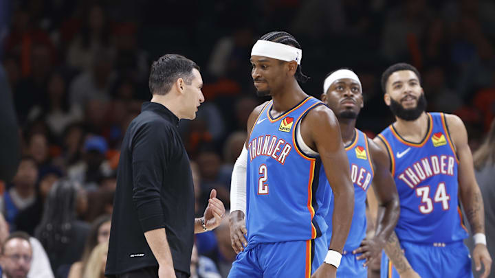 Nov 13, 2024; Oklahoma City, Oklahoma, USA; Oklahoma City Thunder guard Shai Gilgeous-Alexander (2) and head coach Mark Daigneault talk during a time out against the New Orleans Pelicans during the second quarter at Paycom Center. Mandatory Credit: Alonzo Adams-Imagn Images Nov 13, 2024; Oklahoma City, Oklahoma, USA; Oklahoma City Thunder guard Shai Gilgeous-Alexander (2) and head coach Mark Daigneault talk during a time out against the New Orleans Pelicans during the second quarter at Paycom Center. Mandatory Credit: Alonzo Adams-Imagn Images