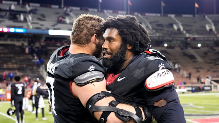 Cincinnati Bearcats offensive lineman Luke Kandra (67), left, and Cincinnati Bearcats defensive end