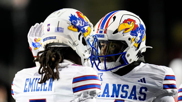 Kansas Jayhawks running back Devin Neal (4), right, pats Kansas Jayhawks wide receiver Doug Emilien (5) s helmet after Neal (4) scores a touchdown during the NCAA college football game between the Cincinnati Bearcats and Kansas Jayhawks on Saturday, Nov. 25, 2023, at Nippert Stadium in Cincinnati. This is the Bearcats last game of the season, as well as their Senior Night Saturday. Kansas Jayhawks running back Devin Neal (4), right, pats Kansas Jayhawks wide receiver Doug Emilien (5) s helmet after Neal (4) scores a touchdown during the NCAA college football game between the Cincinnati Bearcats and Kansas Jayhawks on Saturday, Nov. 25, 2023, at Nippert Stadium in Cincinnati. This is the Bearcats last game of the season, as well as their Senior Night Saturday.