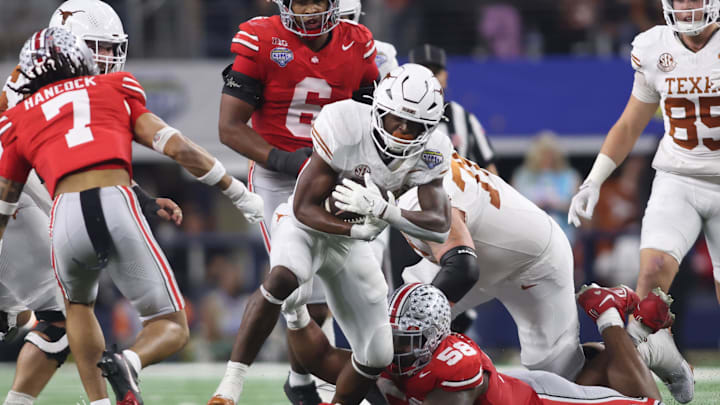 Jan 10, 2025; Arlington, Texas, USA; Texas Longhorns running back Quintrevion Wisner (26) runs against Ohio State Buckeyes cornerback Jordan Hancock (7) and defensive tackle Ty Hamilton (58) during the third quarter of the College Football Playoff semifinal in the Cotton Bowl at AT&T Stadium. Mandatory Credit: Tim Heitman-Imagn Images