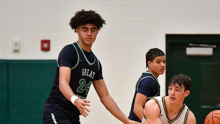 St. Xavier's Will Hanke (35) passes the ball away from the defensive pressure of Great Crossing's Malachi Moreno (24) during the second half of their high school basketball game, Sunday, Dec. 15 2024 in Louisville Ky. St. Xavier won 71-58.