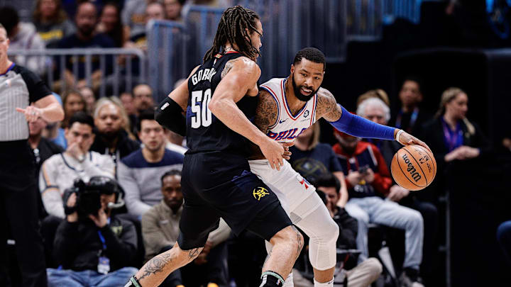 Jan 27, 2024; Denver, Colorado, USA; Philadelphia 76ers forward Marcus Morris Sr. (5) controls the ball under pressure from Denver Nuggets forward Aaron Gordon (50) in the first quarter at Ball Arena. Mandatory Credit: Isaiah J. Downing-Imagn Images