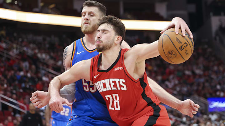 Dec 1, 2024; Houston, Texas, USA; Houston Rockets center Alperen Sengun (28) controls the ball as Oklahoma City Thunder center Isaiah Hartenstein (55) defends during the game at Toyota Center. Mandatory Credit: Troy Taormina-Imagn Images