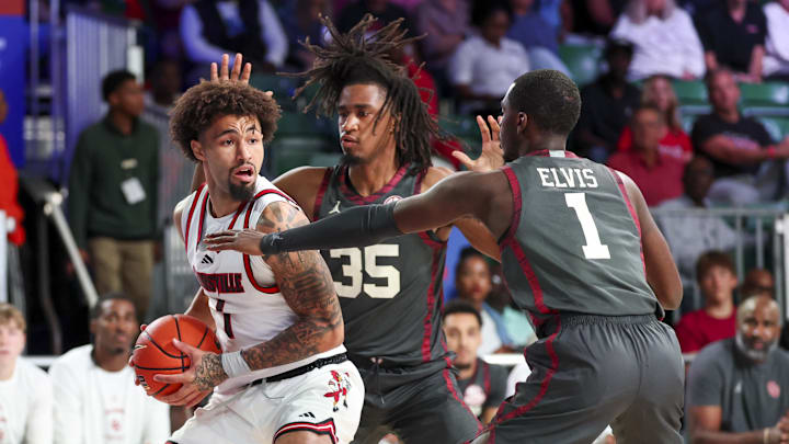 Nov 29, 2024; Paradise Island, Bahamas, BHS;  Louisville Cardinals guard J'Vonne Hadley (1) looks to pass as Oklahoma Sooners forward Glenn Taylor Jr. (35) and Oklahoma Sooners guard Kobe Elvis (1) defend during the first half at Imperial Arena at the Atlantis resort.  Mandatory Credit: Kevin Jairaj-Imagn Images