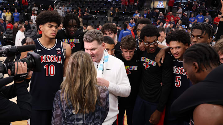Nov 14, 2025; Inglewood, California, USA;  Arizona Wildcats head coach Tommy Lloyd surrounds by his players as he is taking a post game interview after defeating the UCLA Bruins 69-65 at Intuit Dome. Mandatory Credit: Kiyoshi Mio-Imagn Images