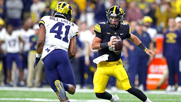 Dec 4, 2021; Indianapolis, IN, USA; Iowa Hawkeyes quarterback Alex Padilla (8) runs the ball against Michigan Wolverines linebacker Nikhai Hill-Green (41) during the third quarter in the Big Ten Conference championship game at Lucas Oil Stadium. Mandatory Credit: Mark J. Rebilas-Imagn Images Dec 4, 2021; Indianapolis, IN, USA; Iowa Hawkeyes quarterback Alex Padilla (8) runs the ball against Michigan Wolverines linebacker Nikhai Hill-Green (41) during the third quarter in the Big Ten Conference championship game at Lucas Oil Stadium. Mandatory Credit: Mark J. Rebilas-Imagn Images