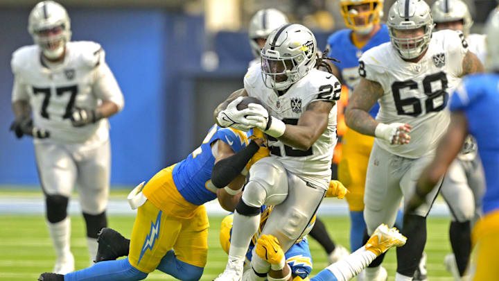 Sep 8, 2024; Inglewood, California, USA; Los Angeles Chargers safety Alohi Gilman (32) and linebacker Daiyan Henley (0) stop Las Vegas Raiders running back Alexander Mattison (22) after a short gain in the second half at SoFi Stadium. Mandatory Credit: Jayne Kamin-Oncea-Imagn Images