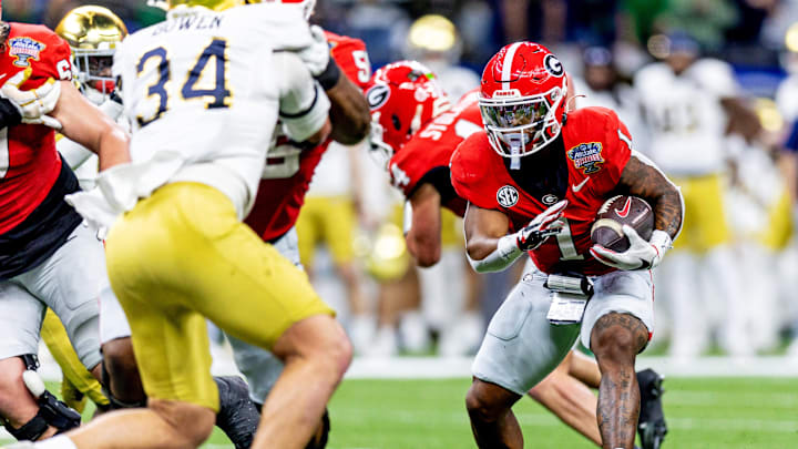 Jan 2, 2025; New Orleans, LA, USA; Georgia Bulldogs quarterback Gunner Stockton (14) runs with the ball as Notre Dame Fighting Irish linebacker Drayk Bowen (34) defends during the second quarter at Caesars Superdome. Mandatory Credit: Stephen Lew-Imagn Images