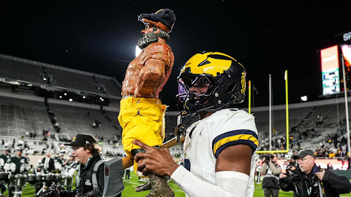 Michigan defensive back Jaden Mangham (3) holds up the the Paul Bunyan Trophy after 31-20 win over Michigan State at Spartan Stadium in East Lansing on Saturday, October 25, 2025.