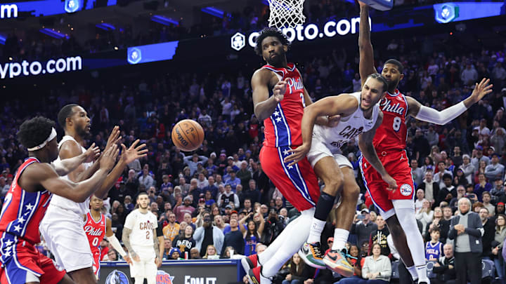 Jan 16, 2026; Philadelphia, Pennsylvania, USA; Cleveland Cavaliers guard Jaylon Tyson (20) passes to center Evan Mobley (4) past Philadelphia 76ers center Joel Embiid (21) in the final seconds of the fourth quarter at Xfinity Mobile Arena. Mandatory Credit: Bill Streicher-Imagn Images