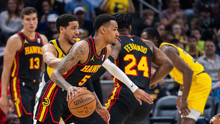 Apr 14, 2024; Indianapolis, Indiana, USA; Atlanta Hawks guard Dejounte Murray (5) dribbles the ball while Indiana Pacers guard Tyrese Haliburton (0) defends in the first half at Gainbridge Fieldhouse. Mandatory Credit: Trevor Ruszkowski-Imagn Images