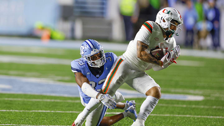 Oct 14, 2023; Chapel Hill, North Carolina, USA; Miami Hurricanes wide receiver Xavier Restrepo (7) escapes from North Carolina Tar Heels linebacker Cedric Gray (33) after a catch in the second half at Kenan Memorial Stadium. Mandatory Credit: Nell Redmond-USA TODAY Sports