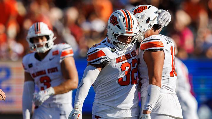 Oklahoma State Cowboys linebacker Ethan Wesloski puts his arm around Oklahoma State Cowboys defensive end James Williams.