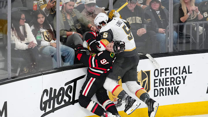 Mar 14, 2026; Las Vegas, Nevada, USA; Vegas Golden Knights defenseman Jeremy Lauzon (5) checks Chicago Blackhawks center Connor Bedard (98) during the third period at T-Mobile Arena. Mandatory Credit: Stephen R. Sylvanie-Imagn Images