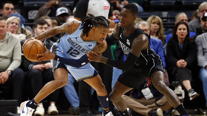 Dec 13, 2024; Memphis, Tennessee, USA; Memphis Grizzlies guard Ja Morant (12) handles the ball as Brooklyn Nets guard Dennis Schroder (17) defends during the first quarter at FedExForum. Mandatory Credit: Petre Thomas-Imagn Images