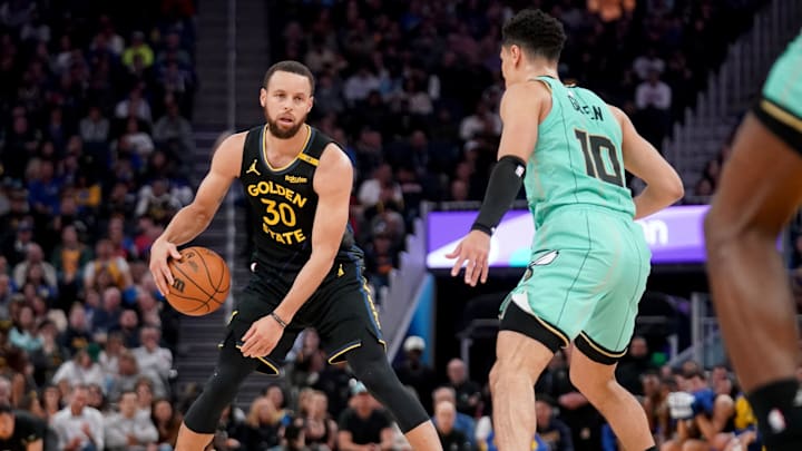 Feb 25, 2025; San Francisco, California, USA; Golden State Warriors guard Stephen Curry (30) dribbles against Charlotte Hornets guard Josh Green (10) in the second quarter at the Chase Center. Mandatory Credit: Cary Edmondson-Imagn Images