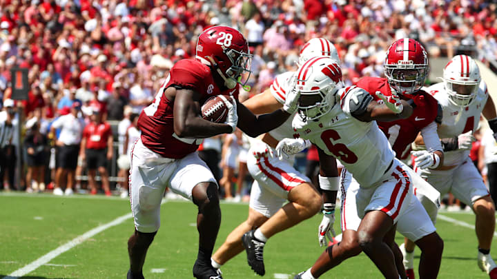 Sep 13, 2025; Tuscaloosa, Alabama, USA; Alabama Crimson Tide running back Kevin Riley (28) avoids a tackle by Wisconsin Badgers cornerback Omillio Agard (6) during the second quarter at Saban Field at Bryant-Denny Stadium. Mandatory Credit: David Leong-Imagn Images