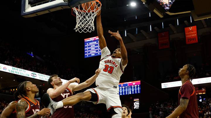 Mar 7, 2026; Charlottesville, Virginia, USA; Virginia Cavaliers center Ugonna Onyenso (33) attempts a dunk as Virginia Tech Hokies center Christian Gurdak (32) defends in the second half at John Paul Jones Arena. Mandatory Credit: Geoff Burke-Imagn Images