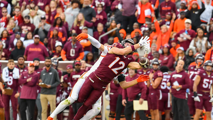 Nov 9, 2024; Blacksburg, Virginia, USA;  Virginia Tech Hokies wide receiver Stephen Gosnell (12) lets a pass slip through his fingers while being defended by Clemson Tigers cornerback Jeadyn Lukus (10) during the second quarter at Lane Stadium. Mandatory Credit: Brian Bishop-Imagn Images