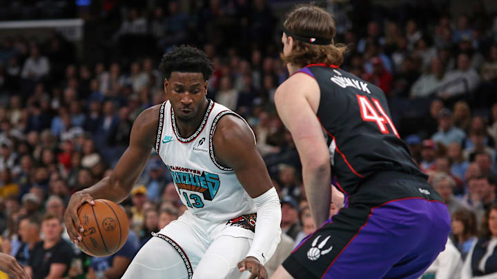 Dec 26, 2024; Memphis, Tennessee, USA; Memphis Grizzlies forward Jaren Jackson Jr. (13) dribbles as Toronto Raptors forward Kelly Olynyk (41) defends during the first quarter at FedExForum. Mandatory Credit: Petre Thomas-Imagn Images