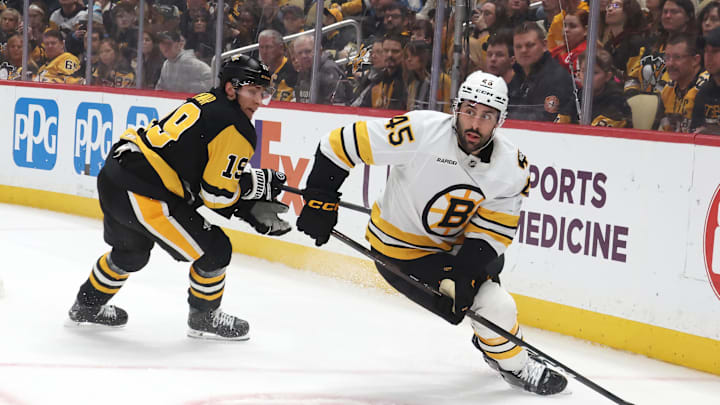 Mar 8, 2026; Pittsburgh, Pennsylvania, USA;  Boston Bruins defenseman Jonathan Aspirot (45) handles the puck against Pittsburgh Penguins center Connor Dewar (19) during the first period at PPG Paints Arena. Mandatory Credit: Charles LeClaire-Imagn Images