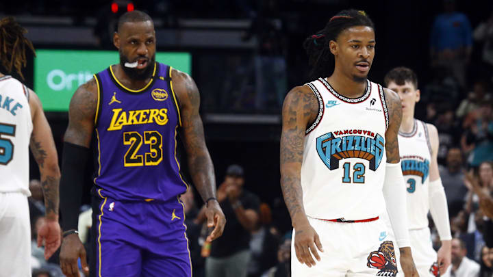 Nov 6, 2024; Memphis, Tennessee, USA; Memphis Grizzlies guard Ja Morant (12)  reacts after a technical foul as Los Angeles Lakers forward LeBron James (23) looks on during the first half at FedExForum. Mandatory Credit: Petre Thomas-Imagn Images