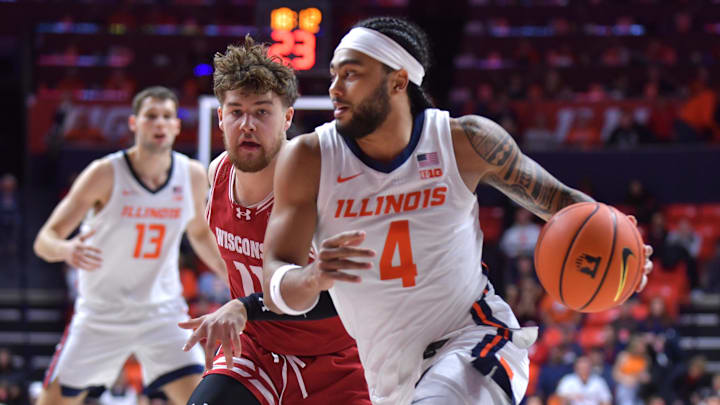 Dec 10, 2024; Champaign, Illinois, USA;  Illinois Fighting Illini guard Kylan Boswell (4) drives the ball past Wisconsin Badgers guard Max Klesmit (11) during the first half at State Farm Center. Mandatory Credit: Ron Johnson-Imagn Images