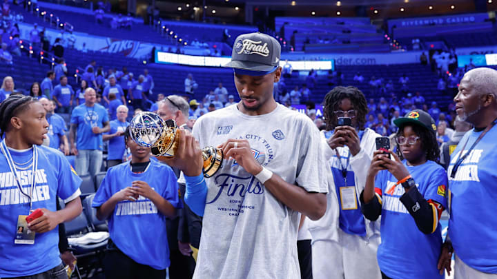 May 28, 2025; Oklahoma City, Oklahoma, USA; Oklahoma City Thunder guard Shai Gilgeous-Alexander (2) looks at his western conference finals MVP trophy after his team defeated the Minnesota Timberwolves in the western conference finals at Paycom Center. Mandatory Credit: Alonzo Adams-Imagn Images