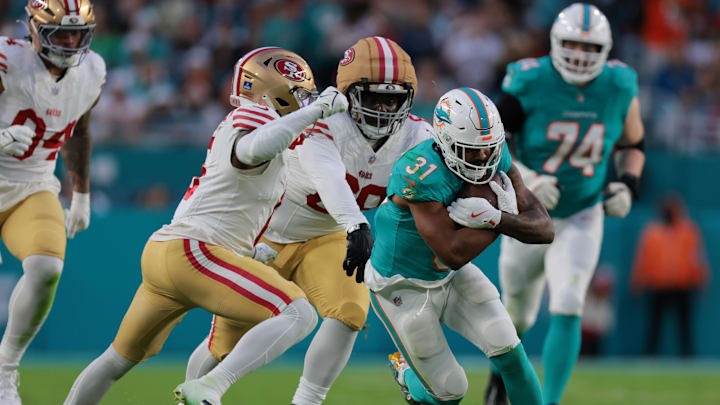 Dec 22, 2024; Miami Gardens, Florida, USA; Miami Dolphins running back Raheem Mostert (31) runs with the football past San Francisco 49ers safety Malik Mustapha (6) and safety Talanoa Hufanga (29) during the second quarter at Hard Rock Stadium. Mandatory Credit: Sam Navarro-Imagn Images Dec 22, 2024; Miami Gardens, Florida, USA; Miami Dolphins running back Raheem Mostert (31) runs with the football past San Francisco 49ers safety Malik Mustapha (6) and safety Talanoa Hufanga (29) during the second quarter at Hard Rock Stadium. Mandatory Credit: Sam Navarro-Imagn Images