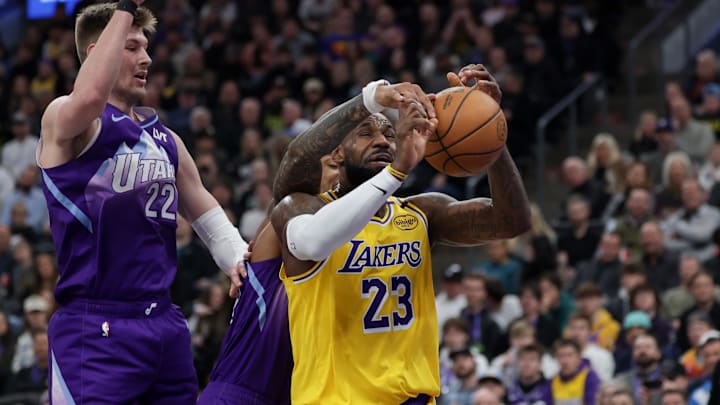 Feb 12, 2025; Salt Lake City, Utah, USA;  Los Angeles Lakers forward LeBron James (23) is fouled by Utah Jazz forward John Collins (20) during the second quarter at Delta Center. Mandatory Credit: Chris Nicoll-Imagn Images