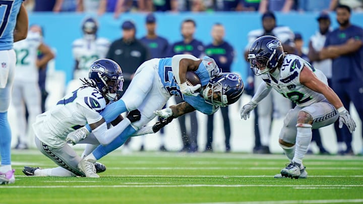 Tennessee Titans running back Tony Pollard (20) is tackled by Seattle Seahawks cornerback Riq Woolen (27) during the fourth quarter at Nissan Stadium in Nashville, Tenn., Sunday, Nov. 23, 2025.