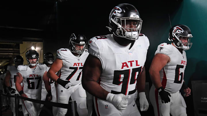 Sep 16, 2024; Philadelphia, Pennsylvania, USA; Atlanta Falcons defensive tackle Eddie Goldman (99) and guard Ryan Neuzil (64) run onto the field against the Philadelphia Eagles at Lincoln Financial Field. Mandatory Credit: Eric Hartline-Imagn Images