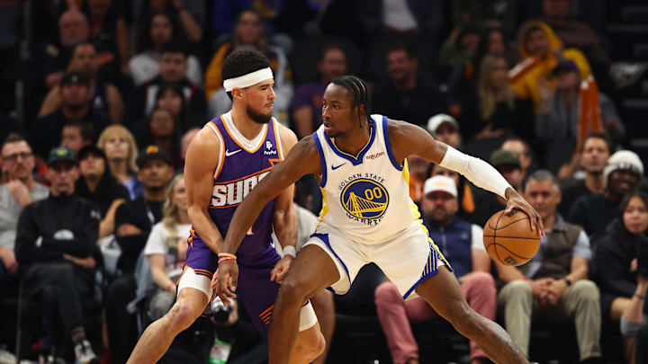 Dec 12, 2023; Phoenix, Arizona, USA; Golden State Warriors forward Jonathan Kuminga (00) against Phoenix Suns guard Devin Booker (1) at Footprint Center. Mandatory Credit: Mark J. Rebilas-Imagn Images