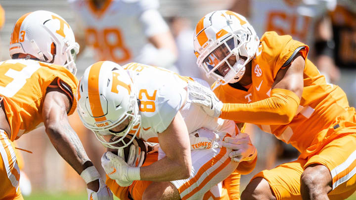 Tennessee defensive back Jordan Matthews (24) tries to take down Tennessee wide receiver Dayton Sneed (82) during Tennessee's Orange & White spring football game at Neyland Stadium on Saturday, April 13, 2024.