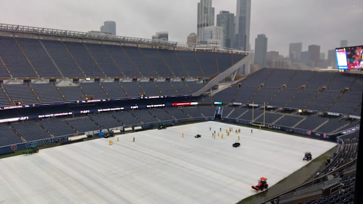 The grounds crew at Soldier Field removes the tarp 2 1/2 hours before the game. IT was still raining hard as it came off.