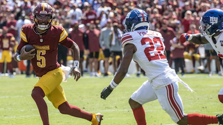 Sep 15, 2024; Landover, Maryland, USA; Washington Commanders quarterback Jayden Daniels (5) scrambles as New York Giants cornerback Dru Phillips (22) track him down during the first half at Commanders Field. Mandatory Credit: Luke Johnson-Imagn Images