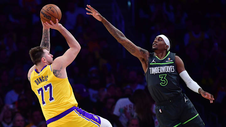 Apr 30, 2025; Los Angeles, California, USA; Los Angeles Lakers guard Luka Doncic (77) shoots against Minnesota Timberwolves forward Jaden McDaniels (3) during the second half in game five of first round for the 2025 NBA Playoffs at Crypto.com Arena. Mandatory Credit: Gary A. Vasquez-Imagn Images