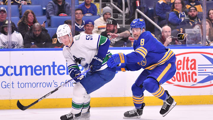 Nov 15, 2022; Buffalo, New York, USA; Vancouver Canucks defenseman Tyler Myers (57) is challenged by Buffalo Sabres center Riley Sheahan (8) with the puck in the second period at KeyBank Center. Mandatory Credit: Mark Konezny-Imagn Images