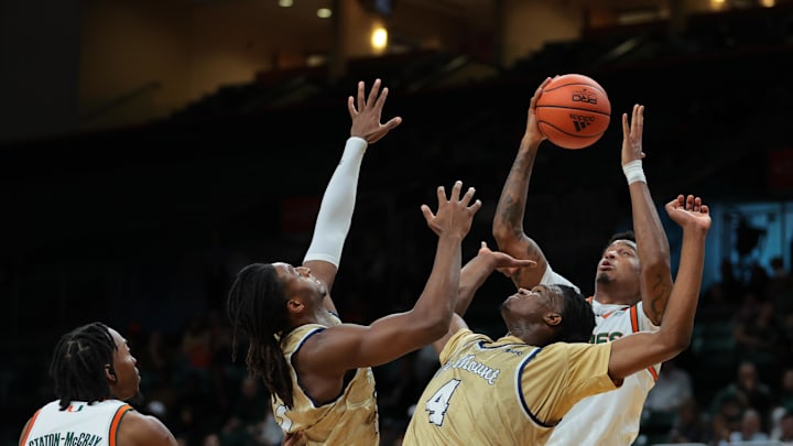 Dec 21, 2024; Coral Gables, Florida, USA; Miami Hurricanes center Lynn Kidd (1) grabs a rebound against Mount St. Mary's Mountaineers forward Dola Adebayo (4) and forward Terrell Ard Jr. (13) during the first half at Watsco Center. Mandatory Credit: Sam Navarro-Imagn Images
