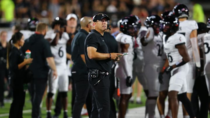 Sep 28, 2024; Lubbock, Texas, USA;  Cincinnati Bearcats head coach Scott Satterfield checks the scoreboard in the second half during the game against the Texas Tech Red Raiders at Jones AT&T Stadium and Cody Campbell Field. Mandatory Credit: Michael C. Johnson-Imagn Images
