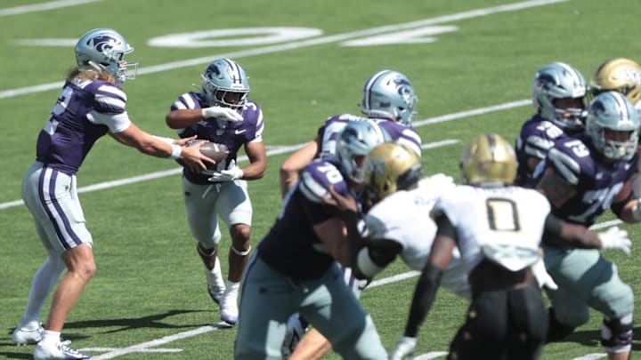 Kansas State Wildcats quarterback Avery Johnson (2) hands the ball to Kansas State Wildcats running back Dylan Edwards.