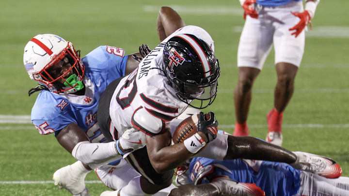 Oct 4, 2025; Houston, Texas, USA;Texas Tech Red Raiders running back J'Koby Williams (20) is tackled by Houston Cougars linebacker Carmycah Glass (25) in the second half  at TDECU Stadium. Mandatory Credit: Thomas Shea-Imagn Images