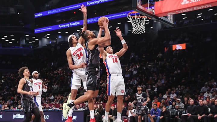 Jan 8, 2025; Brooklyn, New York, USA;  Brooklyn Nets forward Tosan Evbuomwan (12) looks to drive past Detroit Pistons forward Bobi Klintman (34) and guard Wendell Moore Jr. (14) in the fourth quarter at Barclays Center. Mandatory Credit: Wendell Cruz-Imagn Images