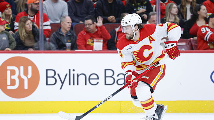 Nov 18, 2025; Chicago, Illinois, USA; Calgary Flames defenseman Rasmus Andersson (4) controls the puck during the second period of NHL game against the Chicago Blackhawks  at United Center. Mandatory Credit: Kamil Krzaczynski-Imagn Images
